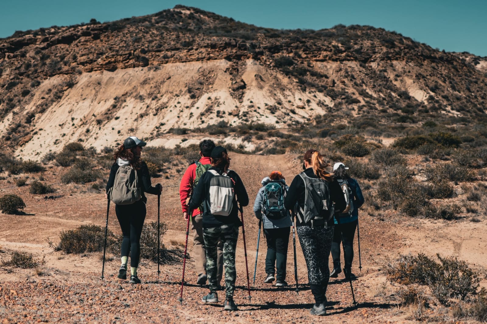 Grupo de turistas haciendo trekking por cerros áridos de la Patagonia